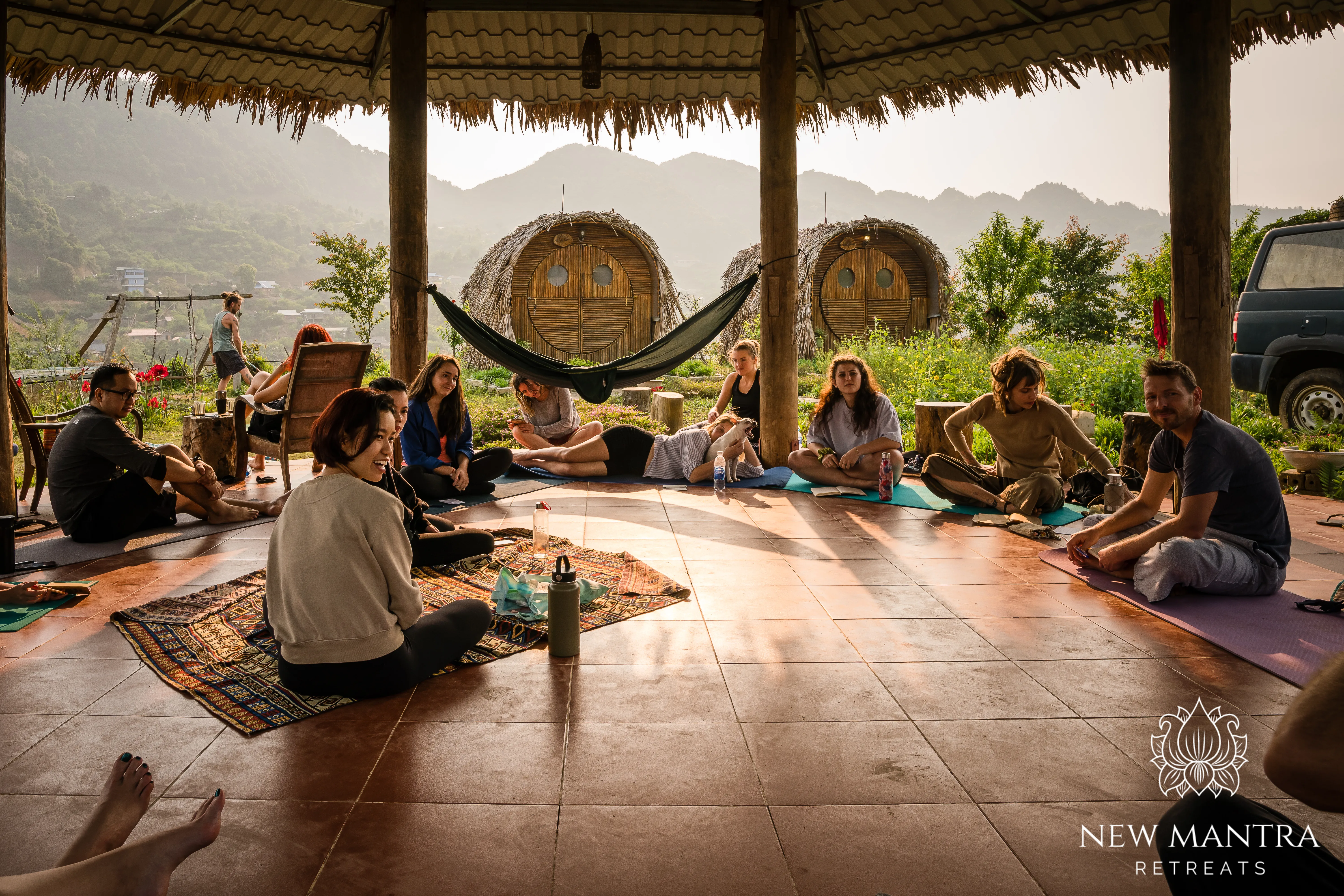 A group gathered together outdoors at a mountain retreat in warm evening light